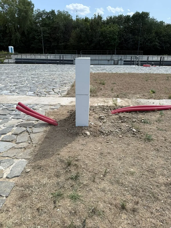 Přípojkový pilíř osazený mezi zaústěnými chráničkami